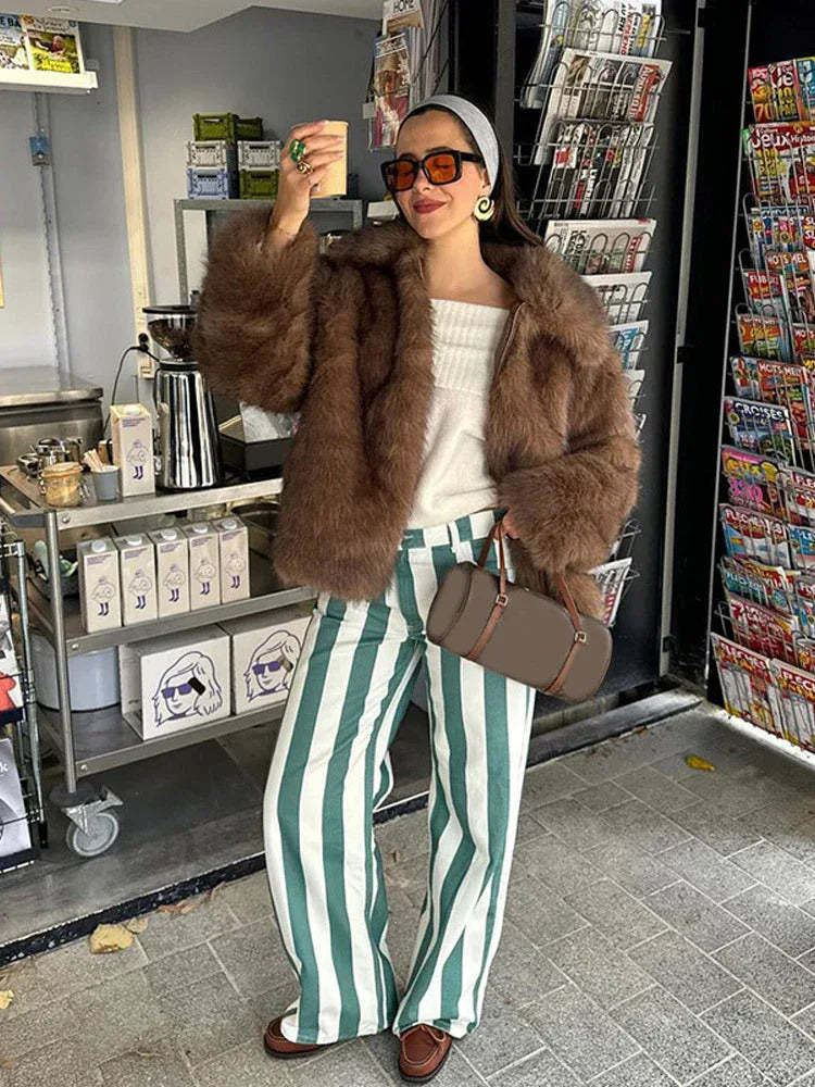 woman wearing a brown faux fur jacket with striped pants and a headband