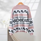 back view of a pink and black geometric print knit cardigan hanging on a wooden hanger