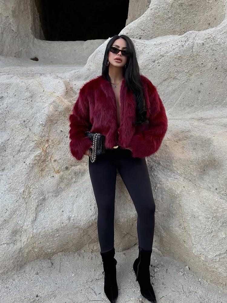 Full body shot of a woman in a burgundy faux fur cropped jacket and black leggings