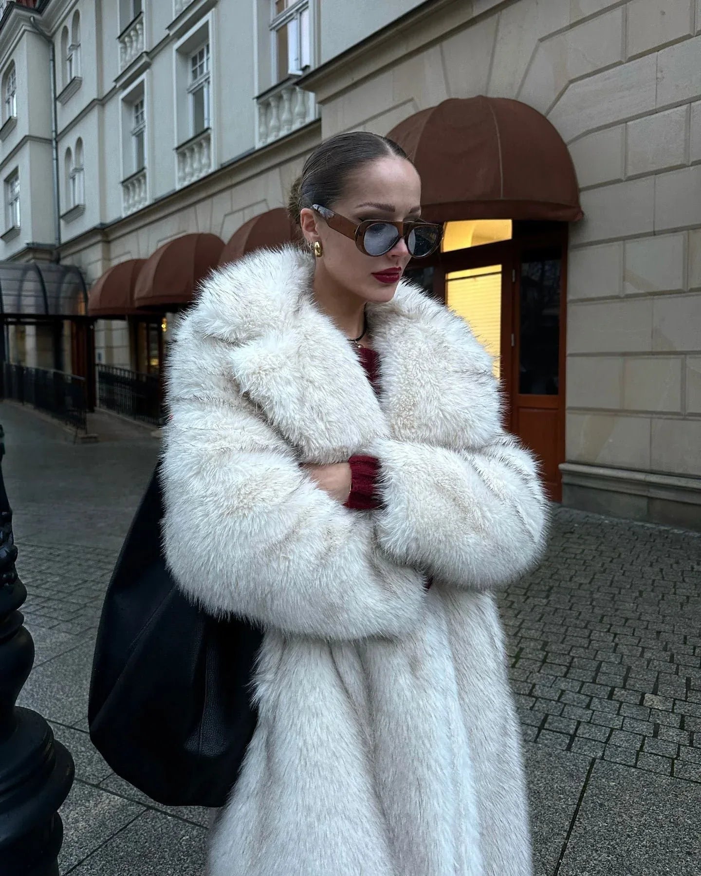 Woman with arms crossed in a white faux fur coat