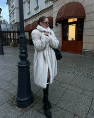 Woman in a white faux fur coat and black boots