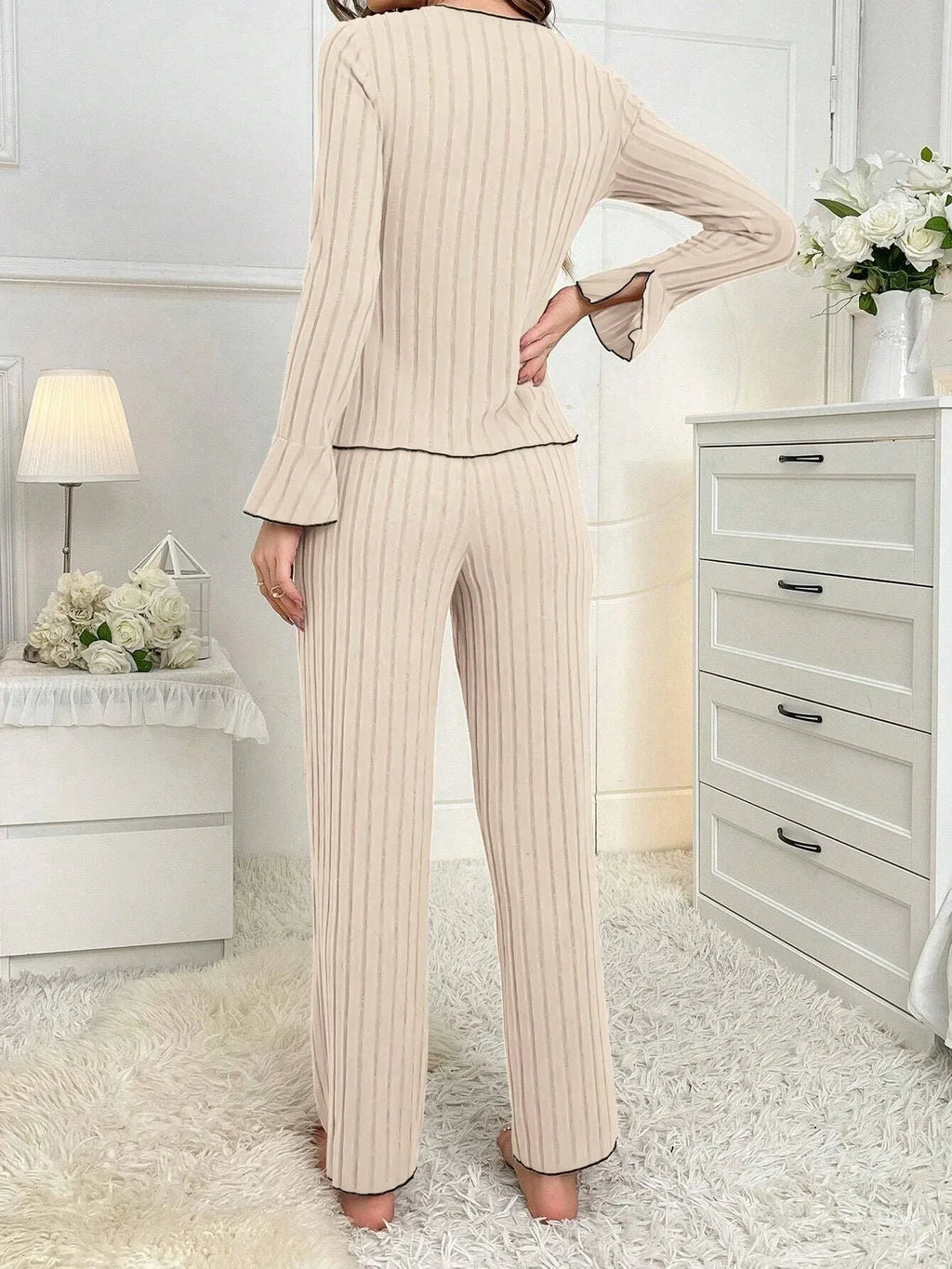 back view of woman in cream ribbed knit pajama set with black trim