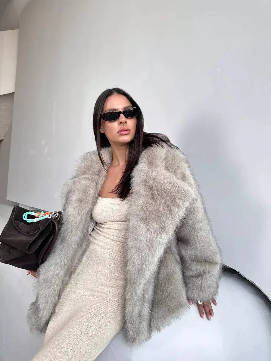 woman wearing a light grey faux fur coat over a cream dress Main image