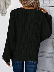 Back view of a woman wearing a black ribbed knit sweater with batwing sleeves and blue jeans.