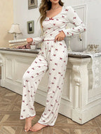 woman wearing white and red bow print pajama set standing next to a dresser