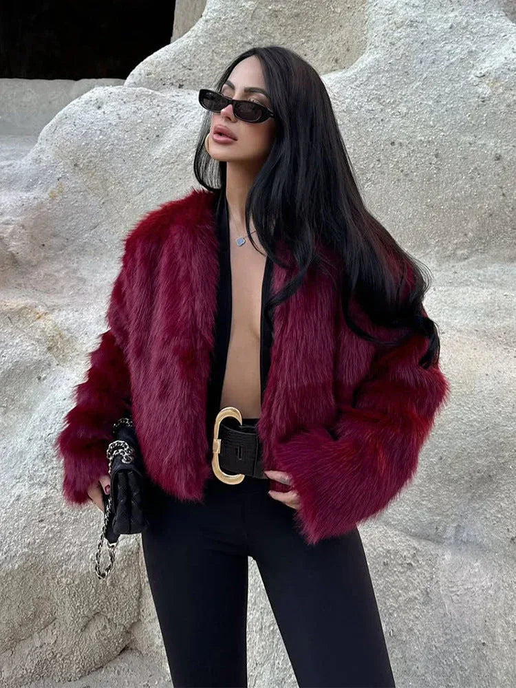 Close-up of a woman wearing a burgundy faux fur cropped jacket and black belt