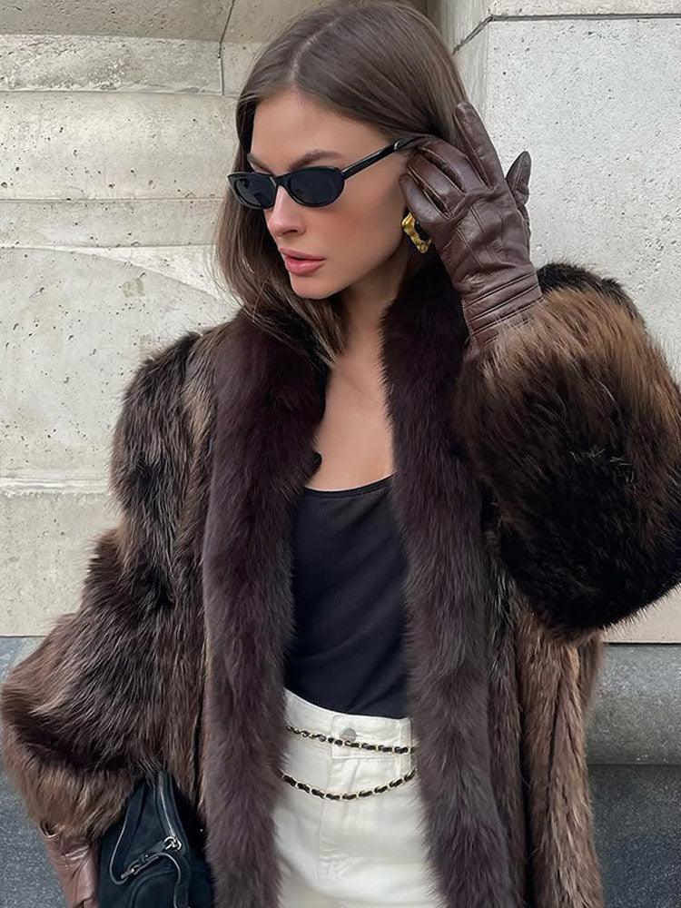 woman adjusting her sunglasses while wearing a stylish brown fur coat and leather gloves