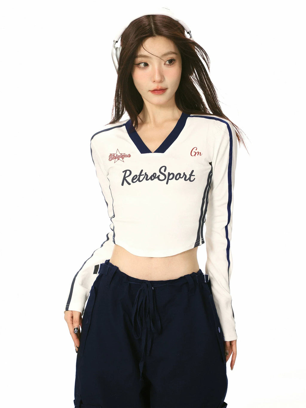 Front view of a woman in a white cropped long-sleeve shirt with contrast trim and 'RetroSport' graphic.