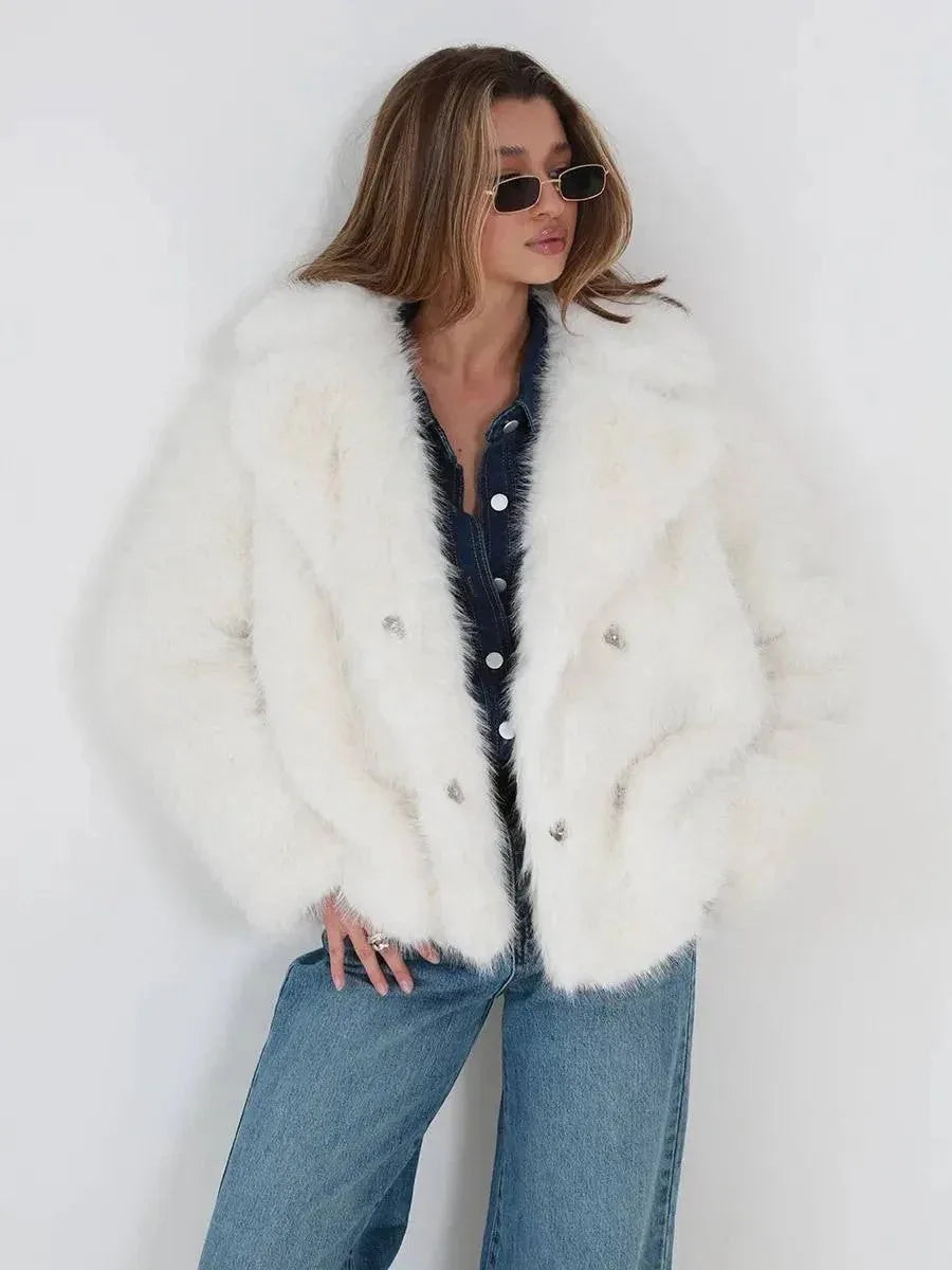 Close-up of the front of a white faux fur jacket worn by a woman.