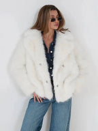 Close-up of the front of a white faux fur jacket worn by a woman.