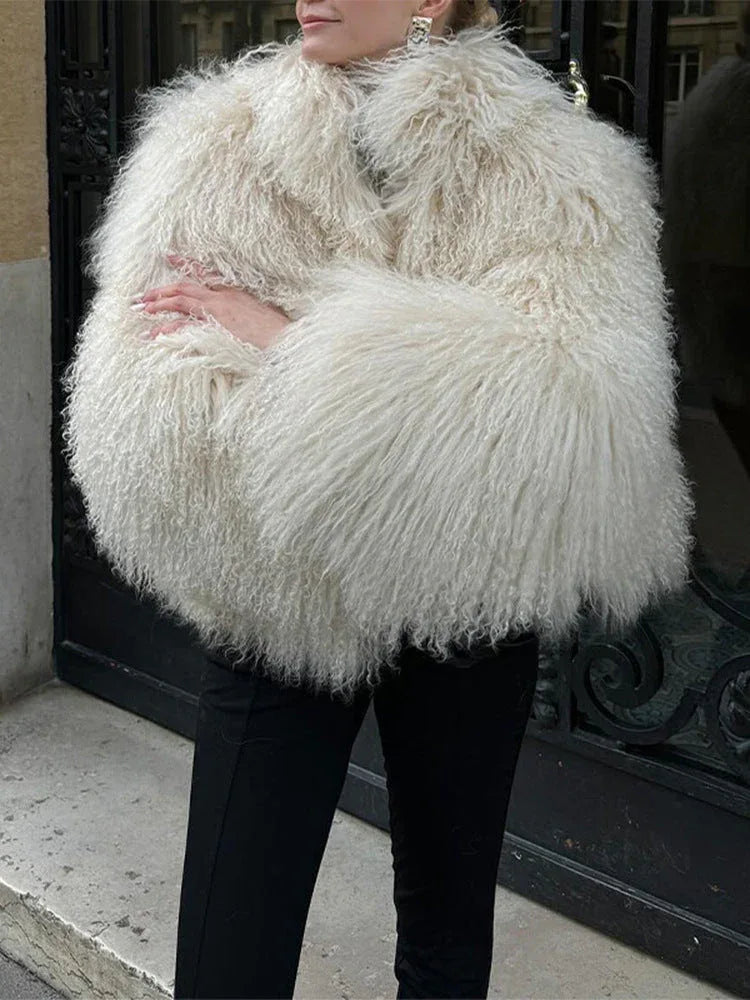 Woman wearing a white shaggy faux fur jacket with black pants Main image