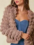 Close-up of a woman wearing a taupe shaggy faux fur coat over a denim corset top