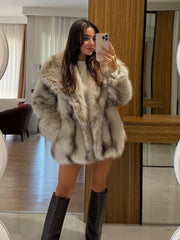 woman wearing a light brown oversized faux fur coat and black boots