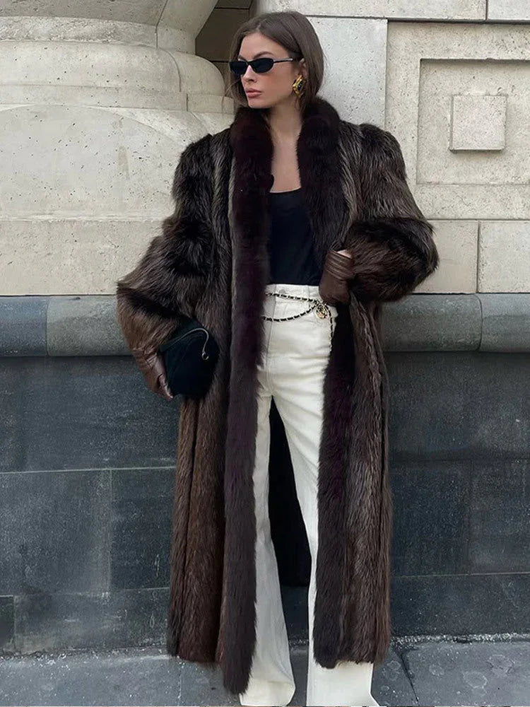 woman wearing a long brown fur coat with white pants and black accessories