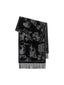 A folded black and white patterned scarf with fringed edges