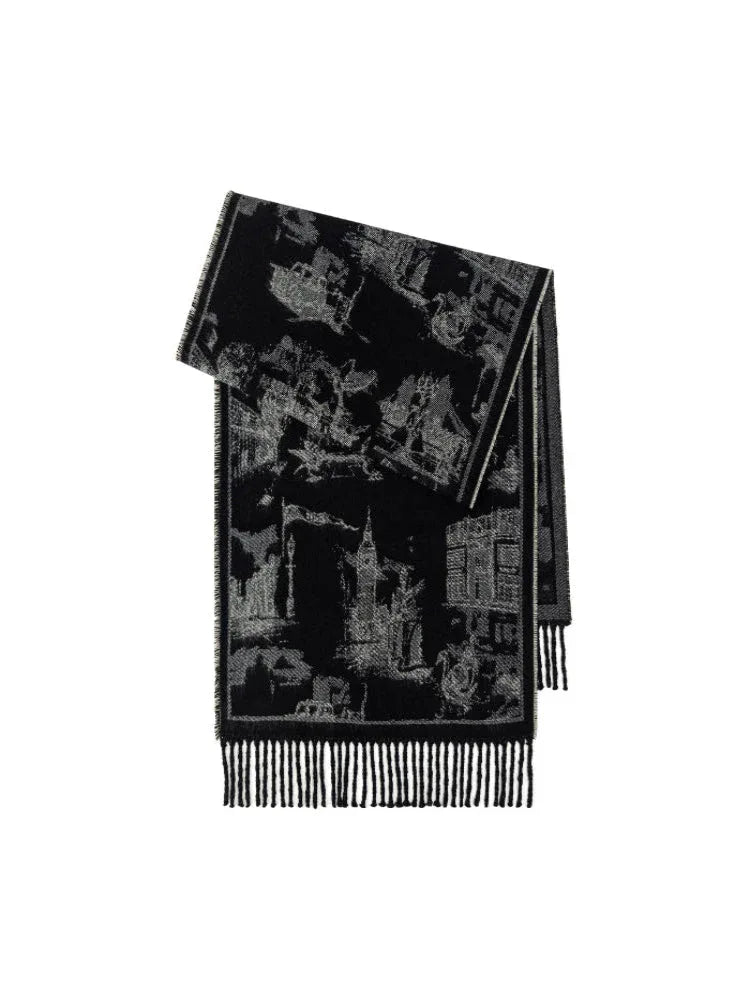 A folded black and white patterned scarf with fringed edges