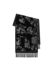 A folded black and white patterned scarf with fringed edges