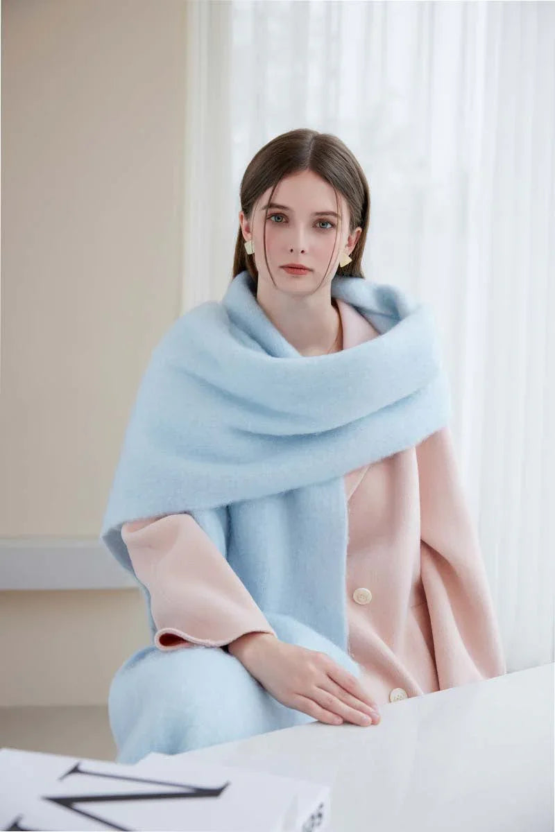 Close-up of a woman wearing a light blue oversized mohair blend scarf.