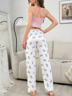 back view of woman wearing pink camisole and floral print pants