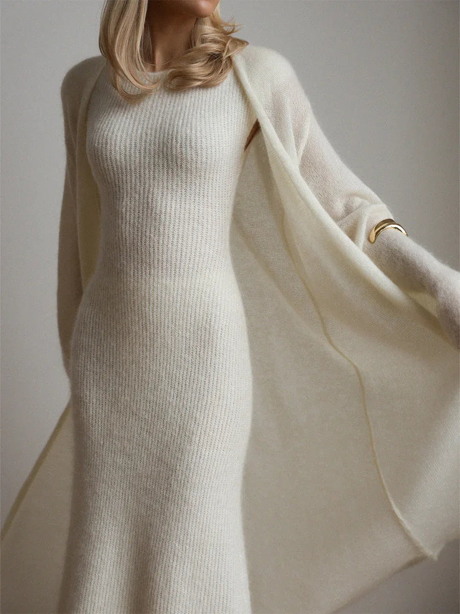 Close-up of a woman wearing a long white ribbed knit dress and a matching flowing cardigan, showing the texture of the knit.