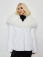 Close-up of a woman wearing a white faux fur short coat with a dramatic collar