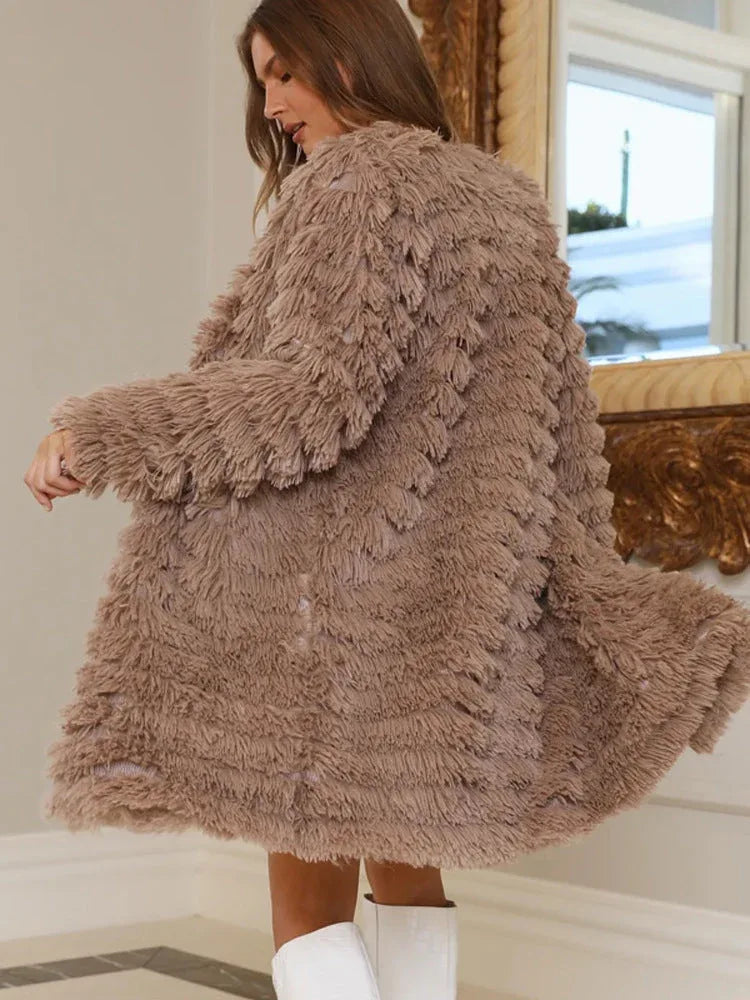 Woman twirling in a taupe shaggy faux fur coat, showing the back and movement of the garment