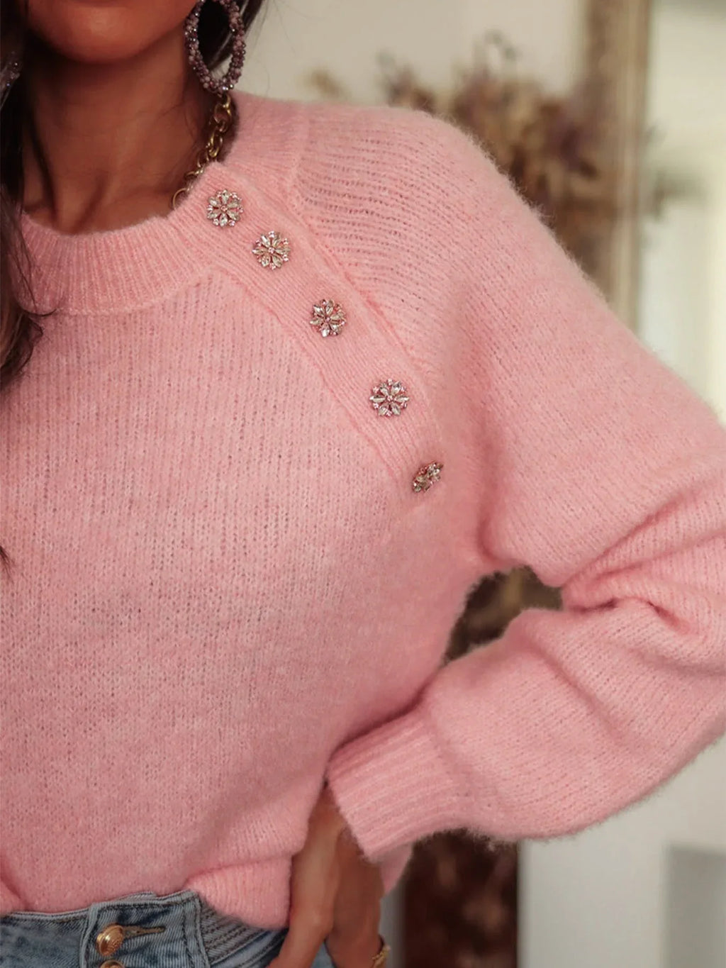 Close-up of the embellished button detail on a pink mohair blend sweater.