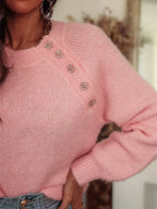 Close-up of the embellished button detail on a pink mohair blend sweater.