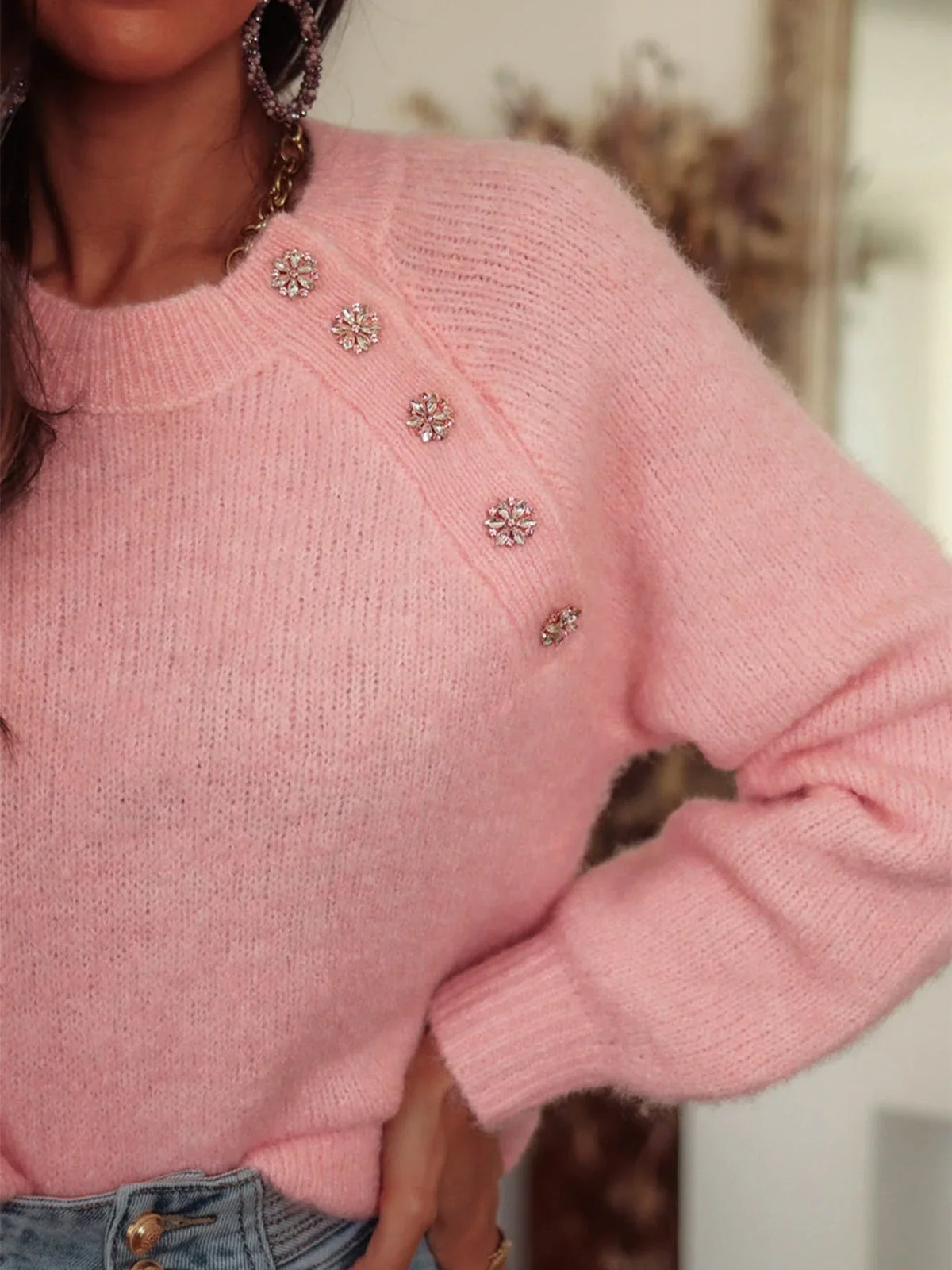 Close-up of the embellished button detail on a pink mohair blend sweater.