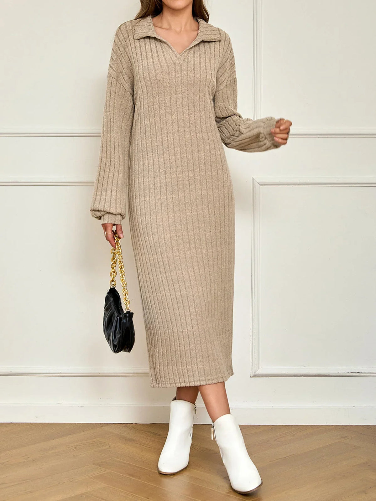 Woman wearing a beige ribbed knit midi dress with a collared V-neck and long sleeves, paired with white ankle boots and a black handbag.