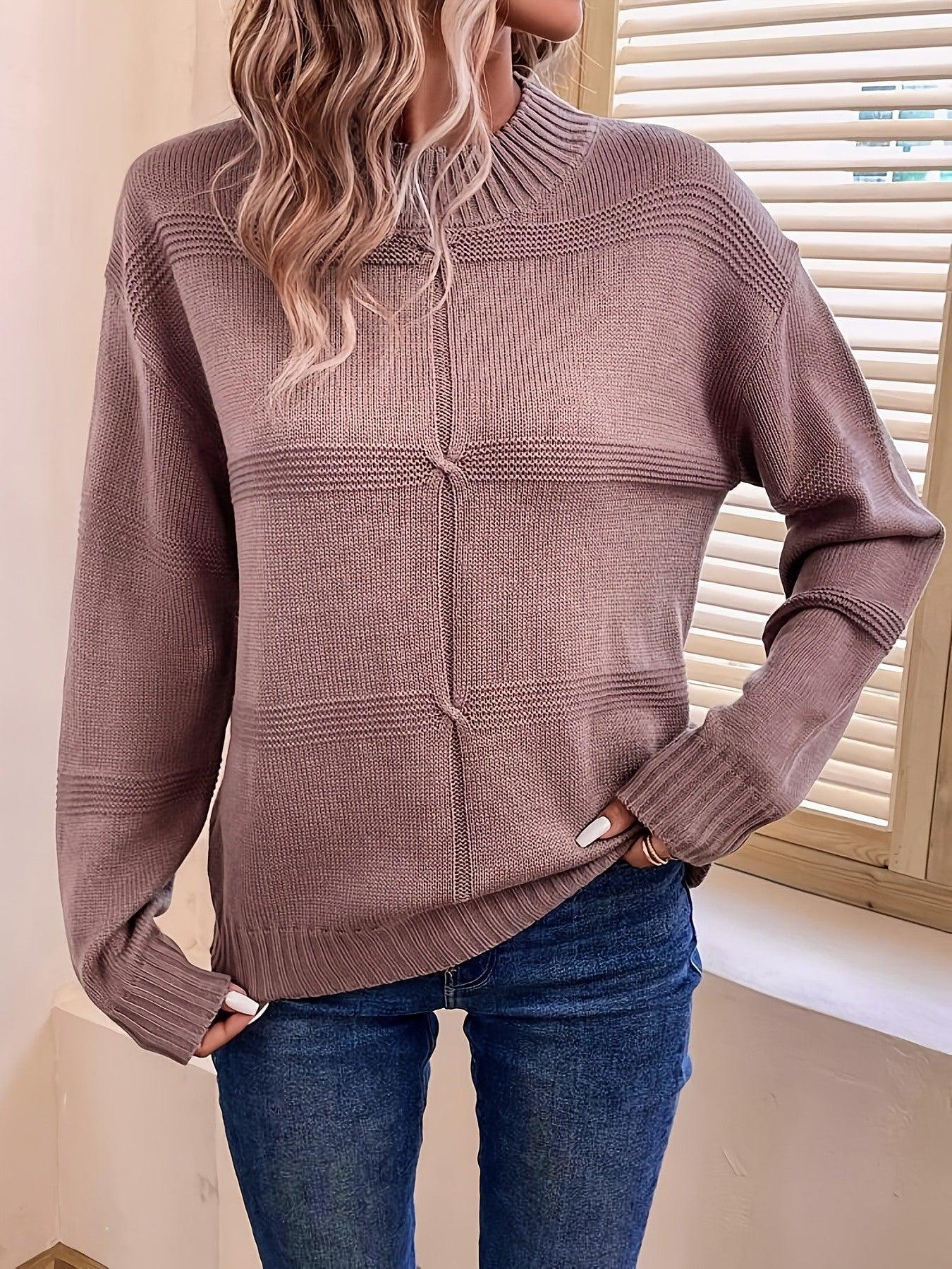 Woman in a mauve knit sweater with a mock neckline and long sleeves, hands tucked into pockets.