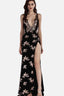 Woman in a black sequined evening gown with a high leg slit and plunging neckline.