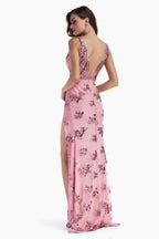 Back view of a woman in a pink sequined evening gown with an open back and high leg slit.