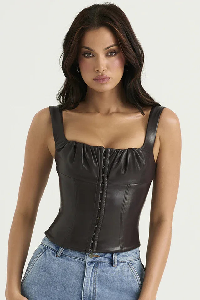 Woman wearing a dark brown faux leather corset top with a square neckline and hook and eye front closure, paired with light wash denim cargo pants. Main image