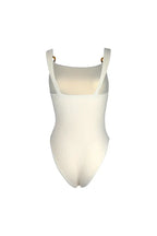 Cream-colored one-piece swimsuit with cut-out details and ring accents, back view.