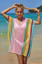 Woman wearing a pink and rainbow striped knit beach cover-up on the beach.