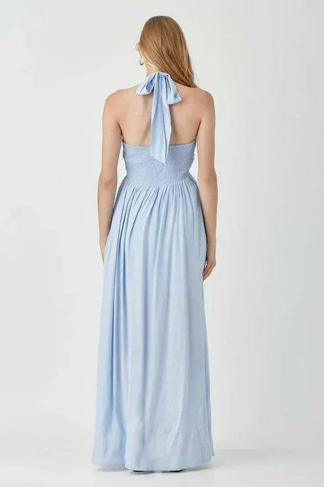 Woman wearing a light blue halter neck maxi dress from the back Secondary image