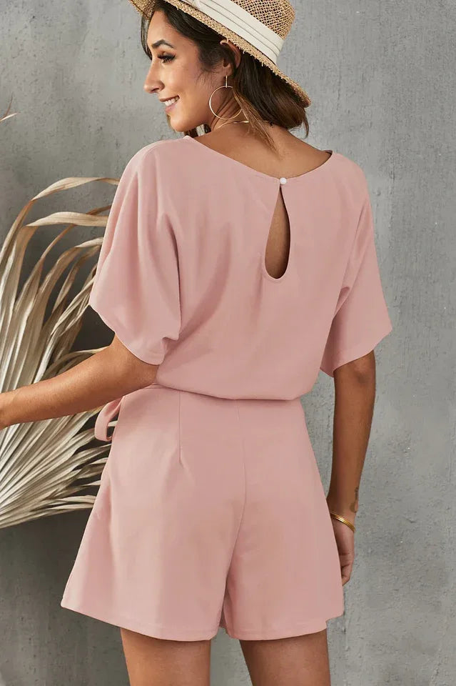 Back view of a woman in a pink romper, showing the keyhole detail on the back. Secondary image