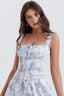 Woman wearing a white floral print corset top with a sweetheart neckline and tie detail