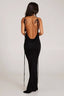 Woman wearing a long black sleeveless cowl neck dress with an open back and adjustable spaghetti straps.