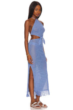 Side view of a woman wearing a blue crochet knit maxi dress with a halter neck and cut-out details.