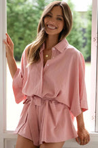 Close-up of a woman smiling, wearing a pink linen-like short set.