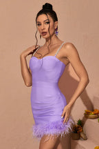 Woman posing in a lavender bandage mini dress with feather trim and jeweled straps.