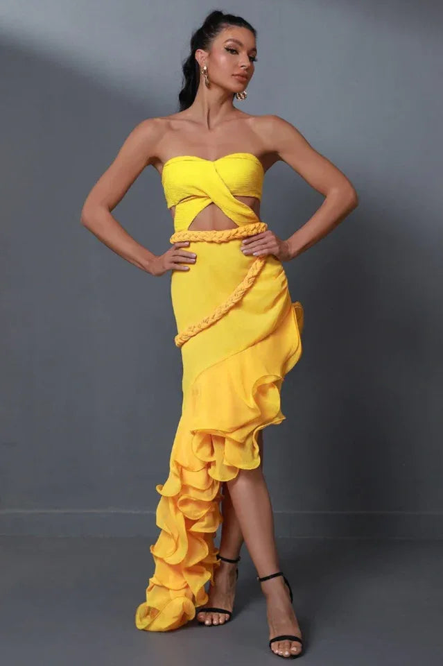woman wearing a yellow strapless dress with a cut-out waist and ruffled asymmetrical hem