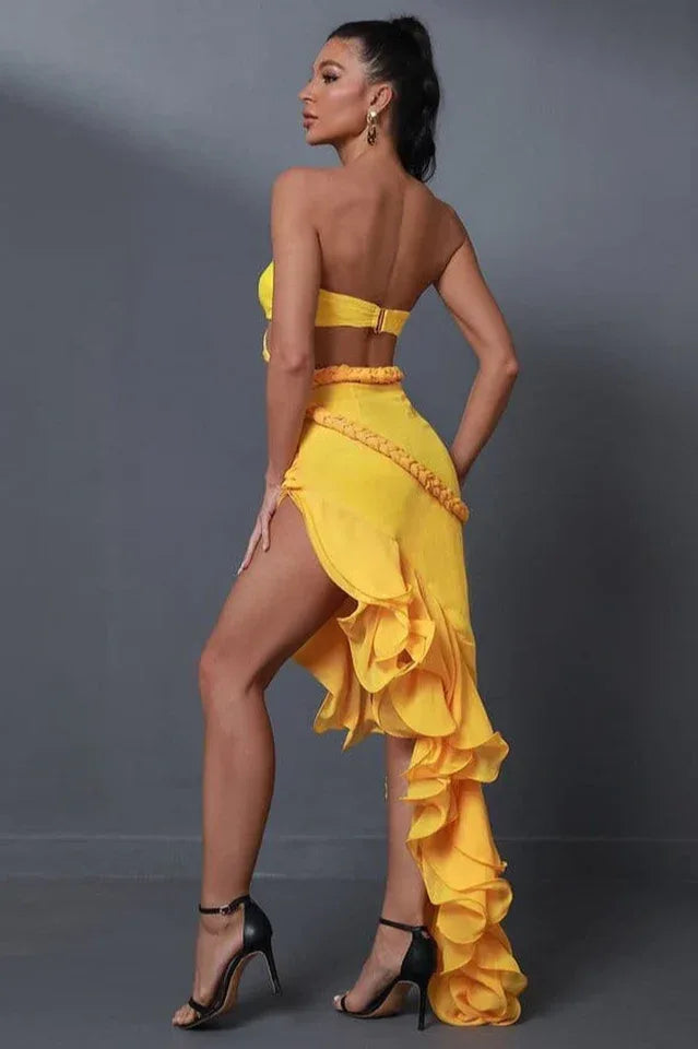 side view of a woman in a yellow strapless dress with a dramatic ruffled train