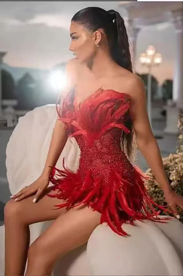 Woman sitting in a red sequined mini dress with feather details