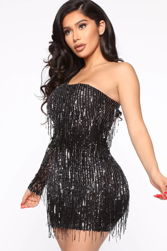Close-up of a woman in a black sequined one-shoulder dress with fringe.