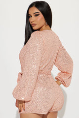 back view of a woman in a pink sequin romper