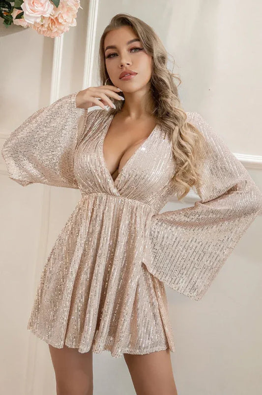 woman wearing a rose gold sequined mini dress with bell sleeves