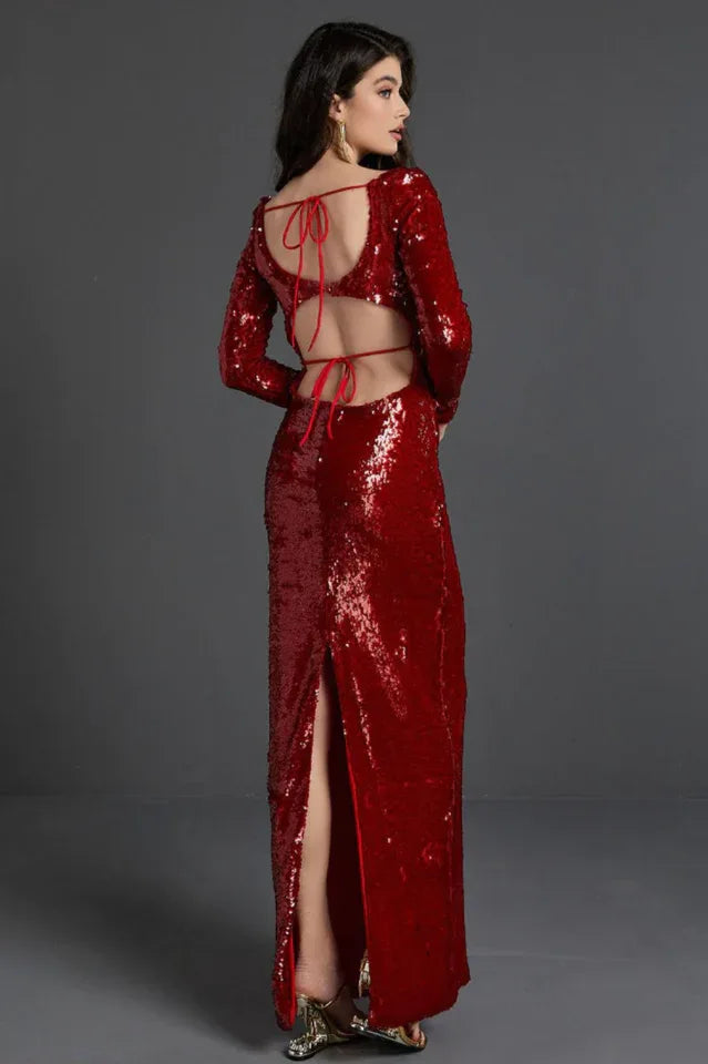 Back view of a woman in a red sequin dress with an open back and tie closure, showing the high slit
